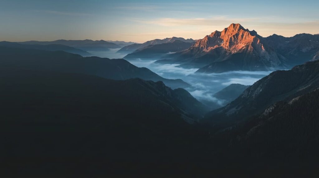A Colorado summit catching first light above a valley of cloud, one thing elevated over many
